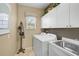 Functional laundry room with washer, dryer, sink, and ample cabinet space at 2016 White Feather Ln, Nokomis, FL 34275