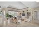 Elegant living room featuring neutral tones, tiled floors, a tray ceiling, and expansive backyard views at 2016 White Feather Ln, Nokomis, FL 34275