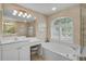 Bright bathroom featuring a soaking tub with a vanity and a tiled walk-in shower at 2016 White Feather Ln, Nokomis, FL 34275