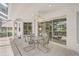Spacious patio area with neutral tones, dining table, ceiling fan, and sliding glass doors leading inside the home at 2016 White Feather Ln, Nokomis, FL 34275