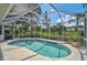 Screened-in backyard pool surrounded by lush landscaping offers a private oasis with a view of the manicured golf course at 2016 White Feather Ln, Nokomis, FL 34275
