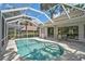 A screened in backyard pool and patio with neutral stones and a dining table located outside the house at 2016 White Feather Ln, Nokomis, FL 34275