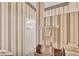 Bright bathroom showcasing a white shower, neutral color palette, and decorative wallpaper at 2025 Lynx Run, North Port, FL 34288