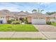 Charming single-story home featuring a well-manicured lawn and a two-car garage with a brick driveway at 2025 Lynx Run, North Port, FL 34288