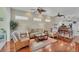 Spacious living room with hardwood floors, neutral paint, and decorative ceiling fan at 2025 Lynx Run, North Port, FL 34288