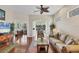 Bright living room with hardwood floors, neutral walls, ceiling fan, and view of a screened-in lanai at 2025 Lynx Run, North Port, FL 34288