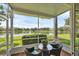 A screened patio offers a peaceful view of a serene lake and lush greenery, perfect for relaxing outdoors at 2025 Lynx Run, North Port, FL 34288
