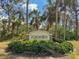Entrance to Foxwood community surrounded by lush tropical landscaping and mature palm trees at 204 Aspen St, Englewood, FL 34223