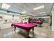 Spacious game room includes two billiards tables, bookshelves, and ample lighting at 204 Aspen St, Englewood, FL 34223