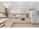This is a traditional kitchen featuring tile floors, and white appliances at 204 Aspen St, Englewood, FL 34223