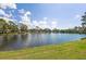 Scenic lake view with lush green grass, blue skies and clouds in this lovely community at 204 Aspen St, Englewood, FL 34223