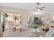 Cozy living room featuring neutral carpeting, a ceiling fan, and access to the lanai and dining room at 204 Aspen St, Englewood, FL 34223
