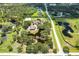 Aerial view of the sprawling estate, showcasing the pond, landscaping, and multiple structures on the property at 21210 77Th E Ave, Bradenton, FL 34202