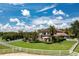 Beautiful backyard with well-manicured lawn, mature trees, and white fencing at 21210 77Th E Ave, Bradenton, FL 34202