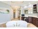 Elegant bathroom features a soaking tub, vanity area, and travertine tile flooring at 21210 77Th E Ave, Bradenton, FL 34202