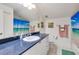 Well-lit bathroom featuring a blue countertop, modern sink, and beach-themed shower curtain and decor at 21210 77Th E Ave, Bradenton, FL 34202