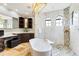 Luxurious bathroom featuring a standalone tub, marble countertops, and custom tile work in the shower at 21210 77Th E Ave, Bradenton, FL 34202