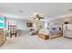 Comfortable bedroom features a ceiling fan, sitting area, and neutral carpeting at 21210 77Th E Ave, Bradenton, FL 34202