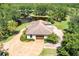 Charming home exterior overlooking a pond, featuring a brown garage door and a circular driveway at 21210 77Th E Ave, Bradenton, FL 34202