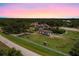A horse grazes near the fenced perimeter of an estate, featuring a main house, a guest house, and an equestrian training area at 21210 77Th E Ave, Bradenton, FL 34202