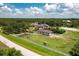 A horse grazes near the fenced perimeter of an estate, featuring a main house, a guest house, and an equestrian training area at 21210 77Th E Ave, Bradenton, FL 34202