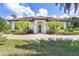 Inviting home entrance with palm trees, a well-manicured lawn, and brick driveway at 21210 77Th E Ave, Bradenton, FL 34202