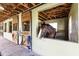 A brown horse looks out from its well-kept stall, complete with wooden doors and proper ventilation at 21210 77Th E Ave, Bradenton, FL 34202