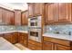 Gourmet kitchen boasts stainless steel appliances, custom cabinets, modern backsplash, and marble countertops at 21210 77Th E Ave, Bradenton, FL 34202