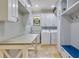 Bright laundry room with white cabinetry, travertine floors, and a folding table at 21210 77Th E Ave, Bradenton, FL 34202