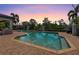 A backyard pool with integrated spa and brick pavers, surrounded by mature trees and lush landscaping at twilight at 21210 77Th E Ave, Bradenton, FL 34202
