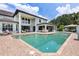 Luxury home featuring a stunning pool with an outdoor kitchen, spa, and ample seating at 21210 77Th E Ave, Bradenton, FL 34202