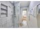 This shower features marble tiling, a glass door and built-in shelving for toiletries at 21210 77Th E Ave, Bradenton, FL 34202