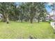 Lush yard with mature trees and well-manicured lawn leading up to a beautiful home at 21210 77Th E Ave, Bradenton, FL 34202