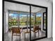 Cozy screened-in balcony with comfortable seating overlooking a lush green landscape at 2155 Harbourside Dr # 804, Longboat Key, FL 34228