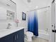 Cozy bathroom featuring a vanity with blue cabinet and a shower with a blue gradient curtain at 2155 Harbourside Dr # 804, Longboat Key, FL 34228