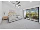Bright bedroom with modern decor, plush carpet, and sliding glass door leading to balcony at 2155 Harbourside Dr # 804, Longboat Key, FL 34228