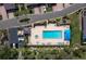 Aerial view of community pool with many lounge chairs, cabana, and parked cars near the lovely green landscape at 2155 Harbourside Dr # 804, Longboat Key, FL 34228