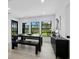 Modern dining room with dark wood furniture and natural light from large windows overlooking lush greenery at 2155 Harbourside Dr # 804, Longboat Key, FL 34228