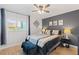 Comfortable bedroom featuring a stylish accent wall, ceiling fan, and natural light from the window at 2415 Bayshore Gardens Pkwy # 2, Bradenton, FL 34207