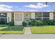 Well-manicured condo building with manicured lawn and tropical plants under a bright sky at 2415 Bayshore Gardens Pkwy # 2, Bradenton, FL 34207