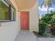 Inviting front entrance with a vibrant door, welcome mat, and lush landscaping, creating a warm ambiance at 2415 Bayshore Gardens Pkwy # 2, Bradenton, FL 34207