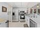 Updated kitchen with stainless steel appliances, white cabinetry, and adjacent laundry at 2415 Bayshore Gardens Pkwy # 2, Bradenton, FL 34207