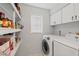 Well-organized laundry room with a modern washer and dryer, open shelving, and ample storage space at 2415 Bayshore Gardens Pkwy # 2, Bradenton, FL 34207