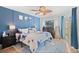 Main bedroom featuring hardwood floors, fan, blue accent wall, and private patio access at 2415 Bayshore Gardens Pkwy # 2, Bradenton, FL 34207