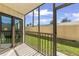 View of the screened-in patio overlooking the grassy backyard and fence at 2415 Bayshore Gardens Pkwy # 2, Bradenton, FL 34207