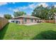 Large, grassy backyard offers plenty of space, featuring a stone patio and wooden fence at 2761 Feiffer Cir, Sarasota, FL 34235