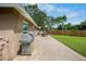 Well-maintained backyard with a stone patio, grill, and a manicured lawn at 2761 Feiffer Cir, Sarasota, FL 34235