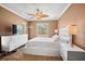 Bedroom featuring neutral walls, white furnishings, and a tropical ceiling fan at 2761 Feiffer Cir, Sarasota, FL 34235