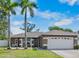 Charming home featuring lush lawn, mature palms, and a two-car garage at 2761 Feiffer Cir, Sarasota, FL 34235