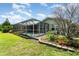 Landscaped backyard featuring a screened pool enclosure, mature trees, and well-maintained lawn at 2919 Shannon Drive, Punta Gorda, FL 33950